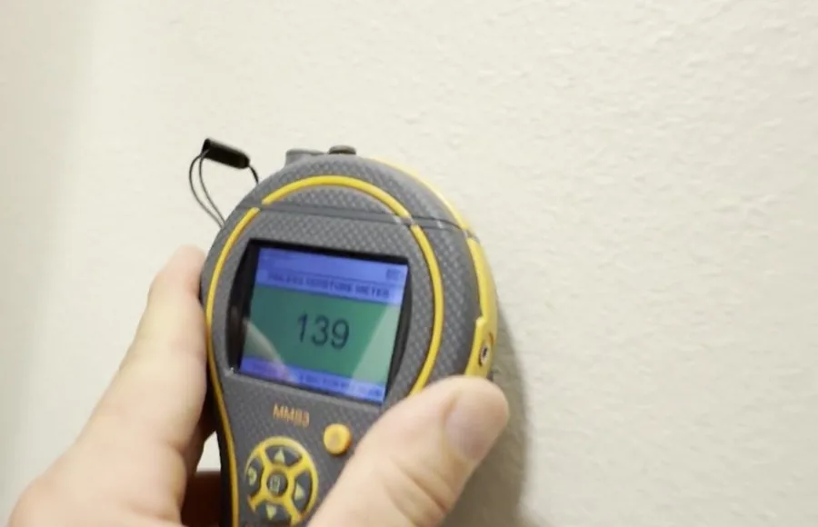 Checking a painted wall with a moisture meter