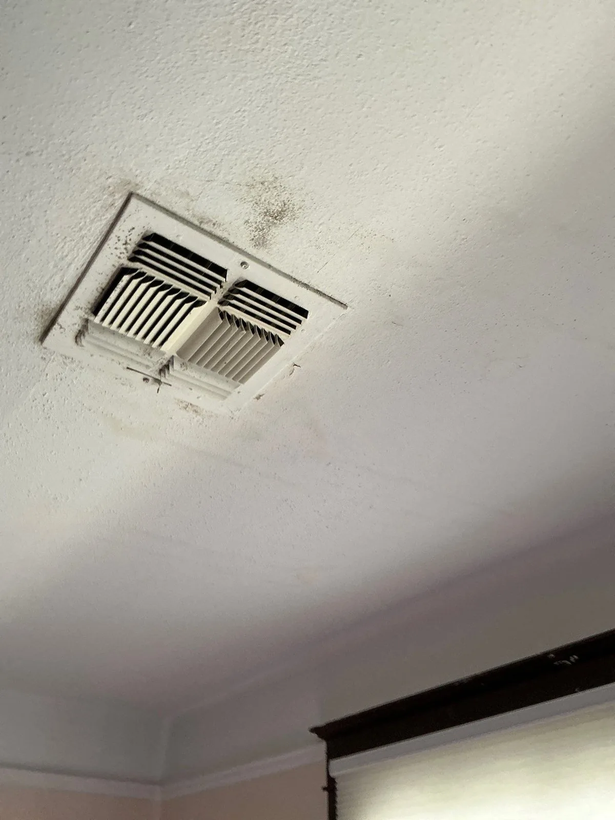 Mold spotting on a ceiling around an A/C supply register